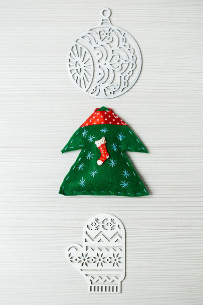 Christmas, new years decor on a wooden white background. Tree, glove, ball. - Фото, зображення