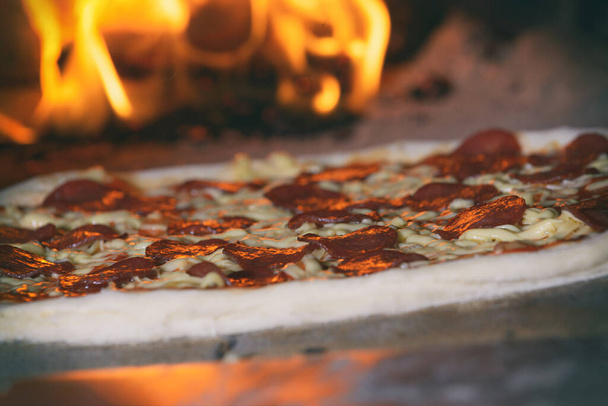Friss, eredeti olasz pizza hagyományos fatüzelésű kőkemencében. - Fotó, kép
