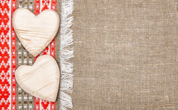 Бурлап фон граничит с деревенской тканью и деревянными сердцами
 - Фото, изображение