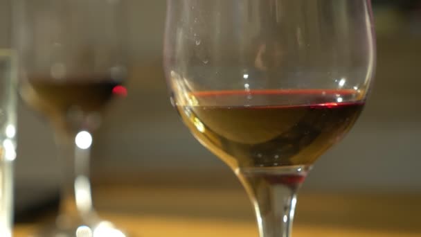 de wijn in de glazen huivert van de luide klanken van muziek. close-up - Video