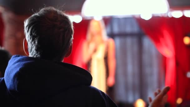 Jovem compartilhando pensamentos com a mulher no palco
 - Filmagem, Vídeo