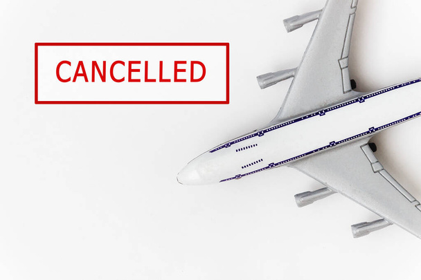 Kırmızı damgalı bir uçak beyaz arka planda iptal edildi. Coronavirüs salgını nedeniyle uçuşlar iptal edildi. Covid-19 'un turizm sektörü üzerindeki etkisi. - Fotoğraf, Görsel