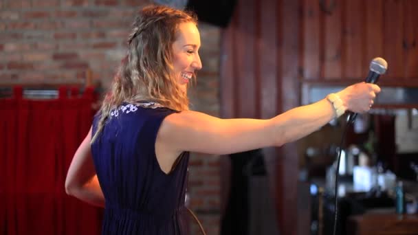 Woman pointing mic at audience to share story - Footage, Video