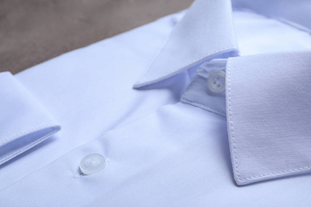 Stylish white shirt on grey table, closeup. Dry-cleaning service - Foto, Imagen