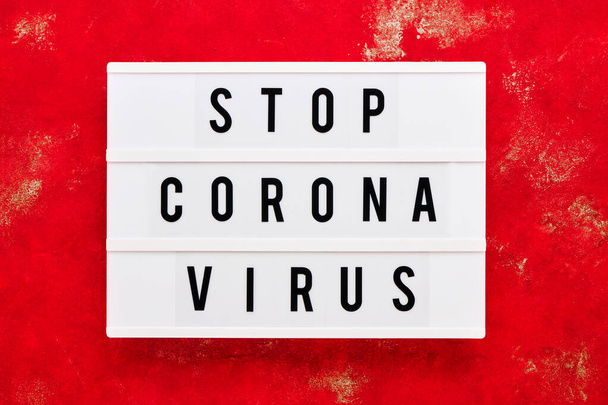 STOP CORONA VIRUS написаний у світлій коробці на червоному тлі. Охорона здоров'я та медична концепція. Вид зверху. Концепція карантину
. - Фото, зображення