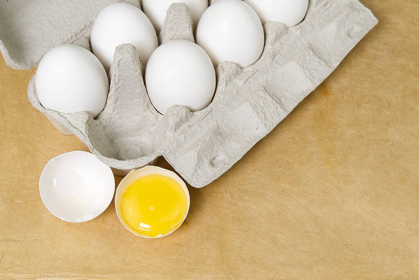 Paper Egg Tray with white eggs. chicken white eggs close up. beige background. broken chicken white egg. - Fotografie, Obrázek