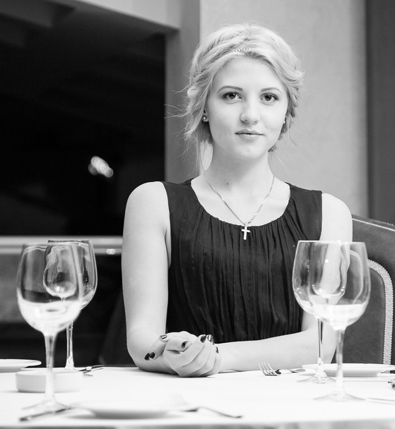 Portrait of sexy woman sitting at restaurant behind table - Fotó, kép