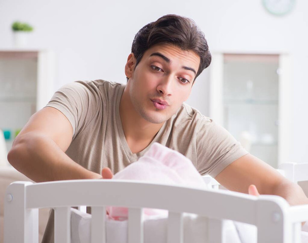 Young father enjoying time with newborn baby at home - Photo, Image