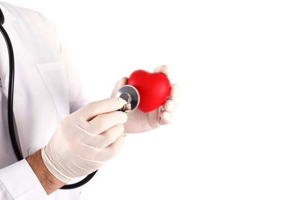 Close-up van mannelijke arts met handschoenen met hart en stethoscoop in de handen - Foto, afbeelding