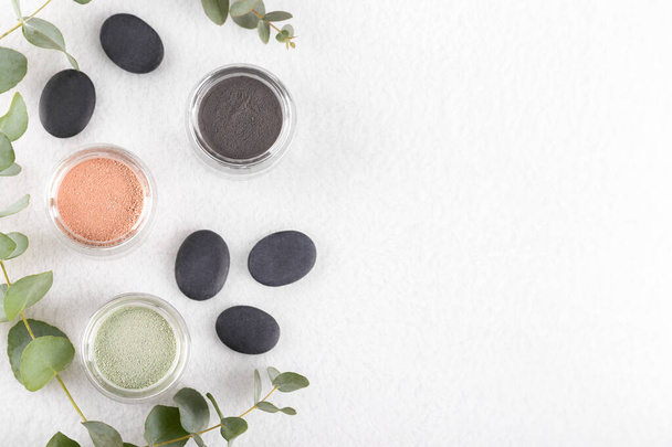 Green,black and pink cosmetic clay powder for skin and hair, spa and wellness, natural cosmetics on white background close up - Photo, Image