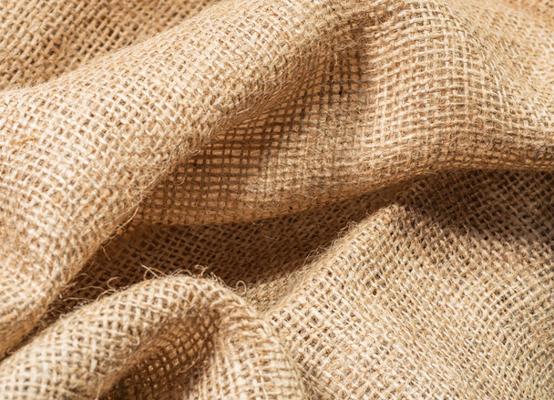 Texture of brown burlap textile, close up view. Crumpled sackcloth, an abstract background. Selective soft focus. Blurred background. - Valokuva, kuva