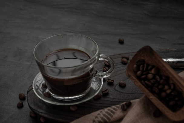 Kahvi tyyli, kuppi kahvia ja kahvipapuja roating vanha puinen kauha ja kahvipapuja ympäri puinen ja tumma kivi tausta. Oblique näkymä ylhäältä kopioi tilaa tekstin
. - Valokuva, kuva