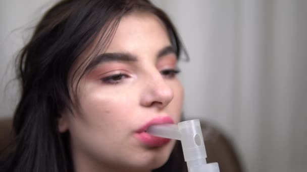 dziewczyna robi inhalacje z nebulizatora w domu chorób układu oddechowego i płuc - Materiał filmowy, wideo