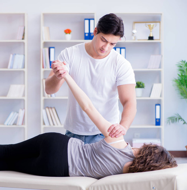 Young doctor chiropractor massaging female patient woman - Фото, изображение