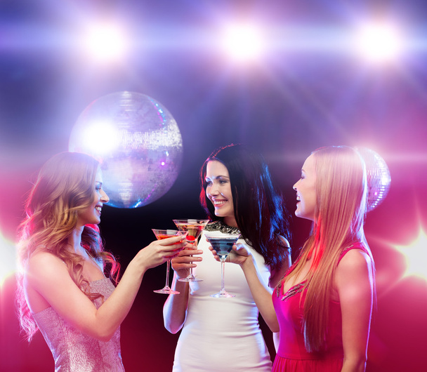 Tres mujeres sonrientes con cócteles y bola disco
 - Foto, imagen