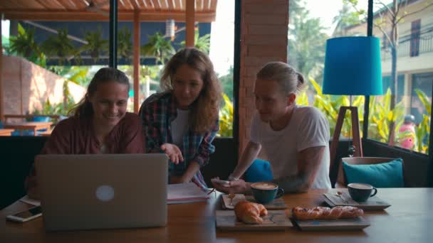 Team junger Mitarbeiter arbeitet an Laptops und diskutiert über Geschäfte - Filmmaterial, Video