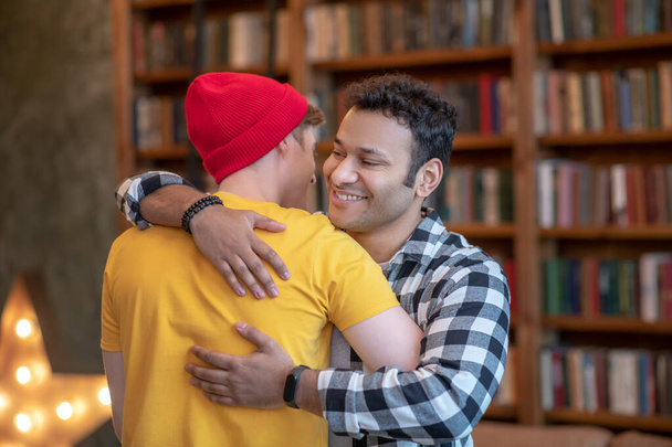 Two young handsome men hugging each other and smiling - Fotografie, Obrázek