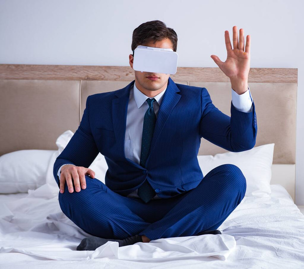 寝室に仮想現実ヘッドセットを身に着けているビジネスマン - 写真・画像