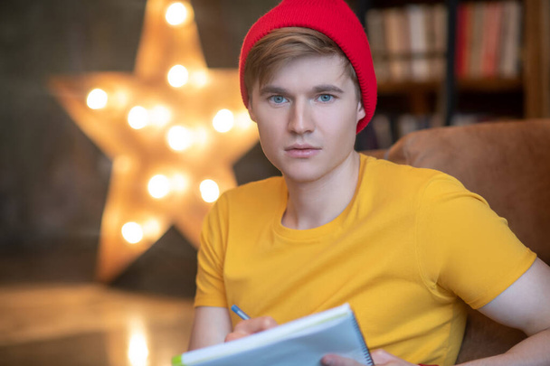 Young man in a red hat looking thoughtful - Photo, image