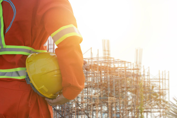 Inženýr drží helmu na staveništi pozadí - Fotografie, Obrázek
