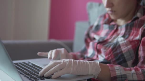 A woman works from home at the computer in silicone gloves - Záběry, video