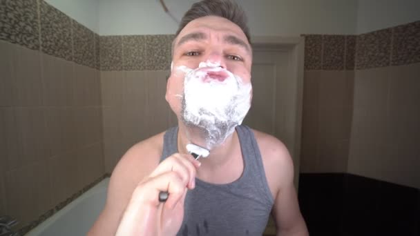 a grown man in the morning shaving in the bathroom - Filmati, video