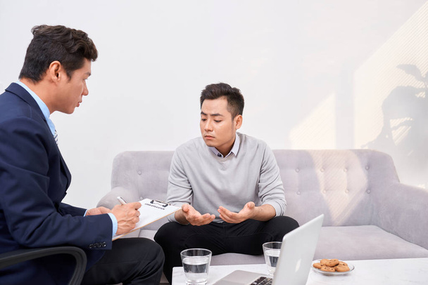 Listen to me. Asian man wrinkling forehead while looking at his therapist - Foto, Bild