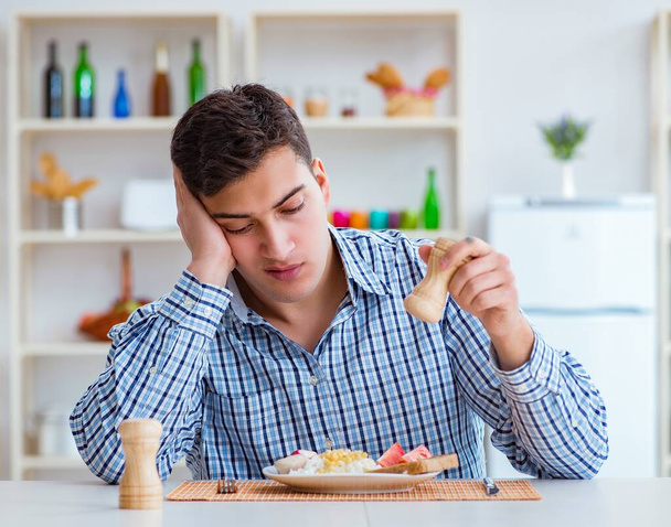 Young husband eating tasteless food at home for lunch - Foto, immagini