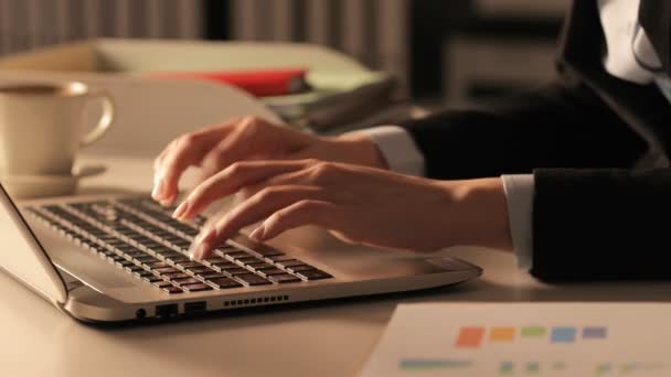 Großaufnahme von Managerhänden, die nachts im Büro auf einem Schreibtisch am Laptop tippen - Filmmaterial, Video