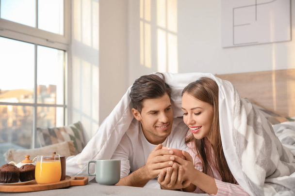 Morning of young couple having breakfast in bed - Photo, Image