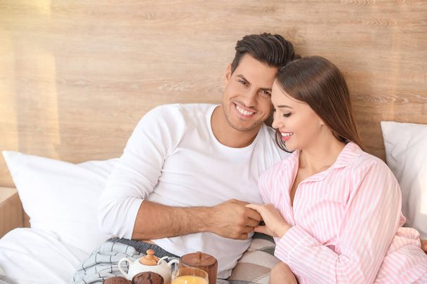 Morning of young couple having breakfast in bed - Фото, изображение