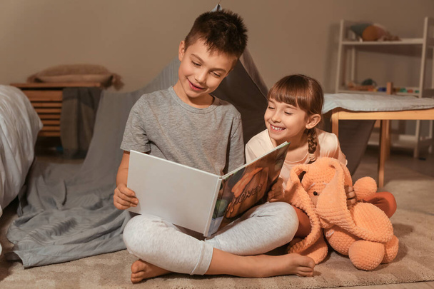 Petits enfants lisant l'histoire du coucher à la maison
 - Photo, image