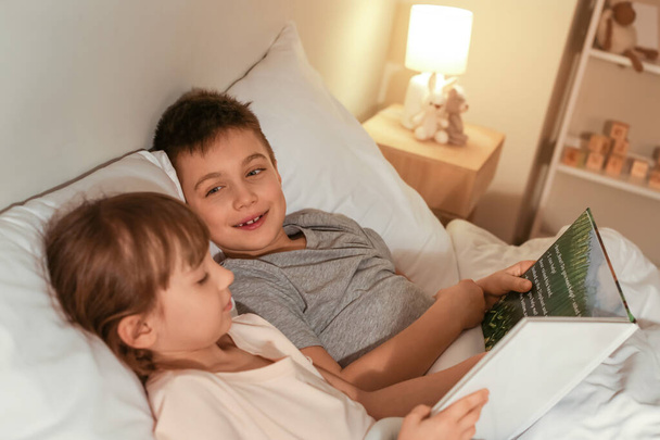 Little children reading bedtime story at home - Foto, Imagem