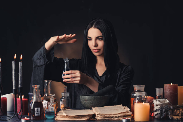 女性化学者は暗い背景でポーションを作る - 写真・画像