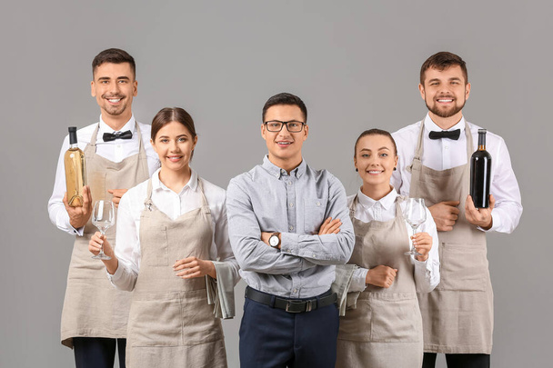 Groep obers met leraar op grijze achtergrond - Foto, afbeelding