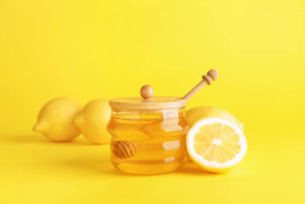 Jar of sweet honey and lemon on color background - Photo, Image