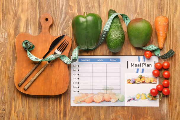 Terveelliset tuotteet ja ateriasuunnitelma mittanauhalla puinen tausta
 - Valokuva, kuva