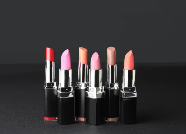 Different lipsticks on dark background - Photo, Image