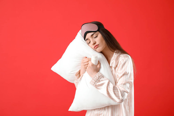Sleeping woman with pills and pillow on color background - Photo, Image