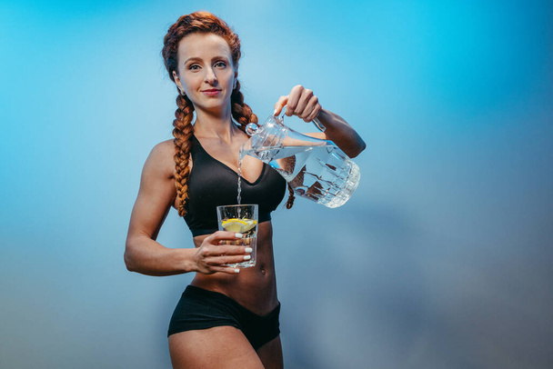 Πόσιμο νερό. Αθλητικό κορίτσι ρίχνει νερό σε ένα ποτήρι. - Φωτογραφία, εικόνα