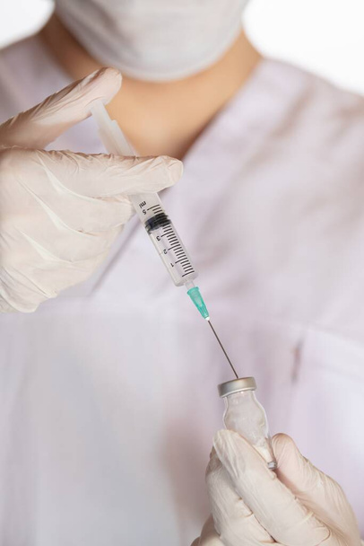 A vertical shot o a doctor holding a vaccine - the concept of corona virus - Photo, Image