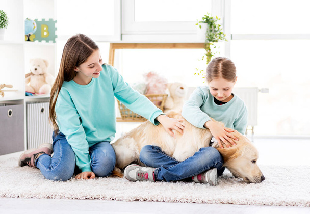 Fröhliche Mädchen streicheln süßen Hund - Foto, Bild
