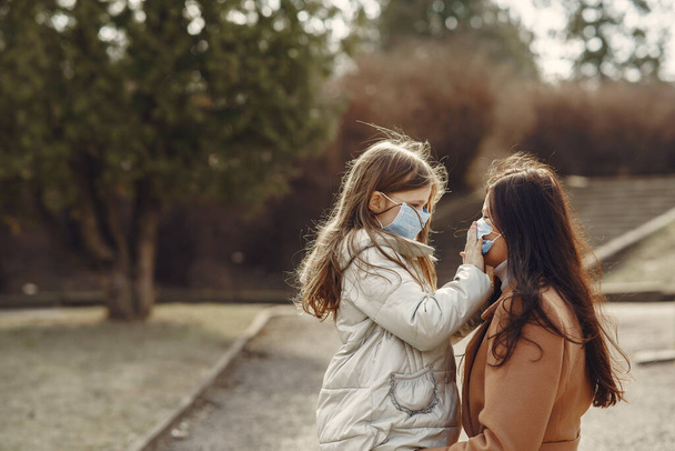 Мать с дочерью выходит на улицу в масках - Фото, изображение