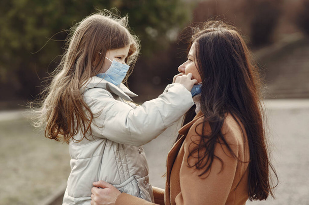 Mother with daughter walks outside in masks - Фото, зображення