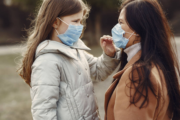 Mother with daughter walks outside in masks - Photo, Image