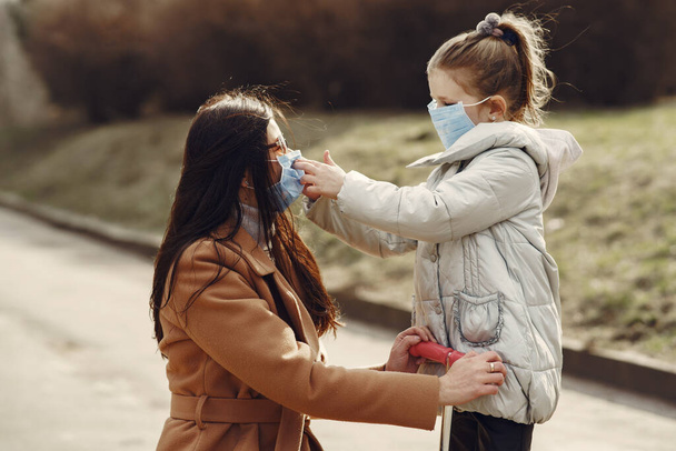 Mother with daughter walks outside in masks - Foto, afbeelding