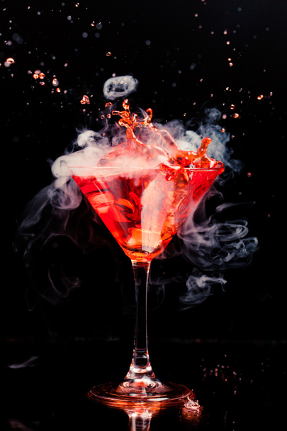 червоний коктейль зі сплеском і льодовою парою
 - Фото, зображення