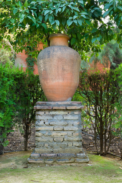 Urna de jardim em um grande suporte de tijolo como uma característica decorativa
 - Foto, Imagem