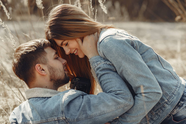 Cute couple in a jeans clothes in a spring field - Φωτογραφία, εικόνα