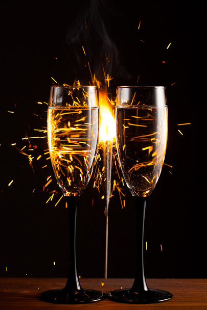 champagne glasses against christmas sparkler background - 写真・画像